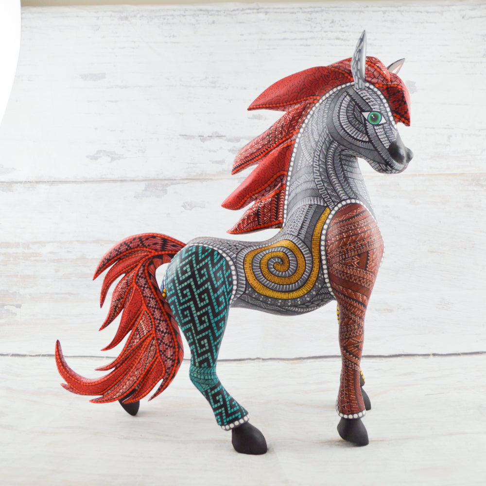 Colorful Mexican alebrije shaped like a horse, featuring intricate carvings and vibrant patterns, showcasing traditional craftsmanship and artistic detail