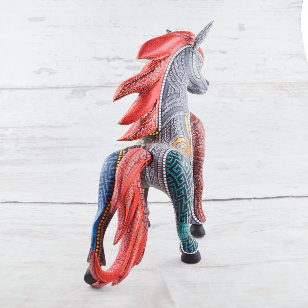 Colorful Mexican alebrije shaped like a horse, featuring intricate carvings and vibrant patterns, showcasing traditional craftsmanship and artistic detail