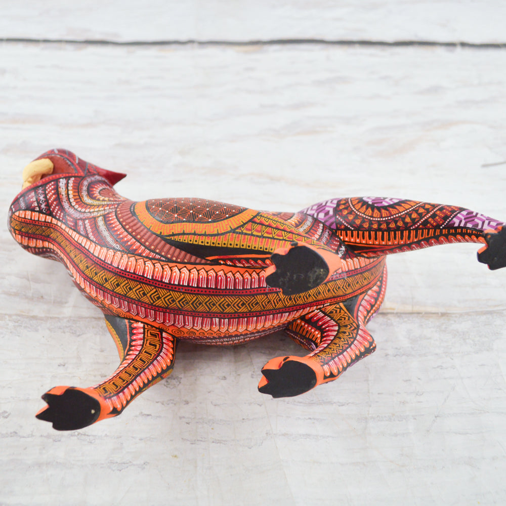 magiamexica.com - Vivid Mexican alebrije shaped like a jaguar, intricately carved and painted with bright colors and detailed patterns, reflecting traditional folk art